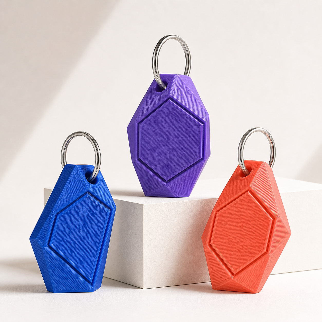 Chaveiros corporativos personalizados impressos em 3D nas cores azul, violeta e coral